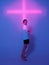 Cool young girl standing in blue neon light with pink cross in studio. Trendy poster to announce party