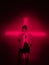 Cool young girl standing in cross shaped red neon light in studio. Trendy poster to announce Halloween party