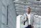 Cool young man walking inside station building with bag