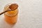 Cooled down congealed beef bone broth in a glass jar and on a spoon  on a white background with copy space