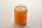 Cooled down congealed beef bone in a glass jar on a white background