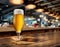 Cooled glass of beer with condensate on the wooden table. Blurred bar at the background