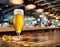 Cooled glass of beer with condensate on the wooden table. Blurred bar at the background