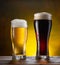 Cooled glasses of pale and dark beer with condensation drops on the wooden table