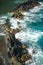 Cooled lava and ocean waves. View of sea waves hitting rocks on the beach. Waves and rocks.