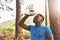 Cooling down after an intense workout. a sporty young man pouring water over his face while out for a run in the forest.