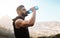 Cooling off after an intense workout. a sporty young man drinking water while exercising outdoors.