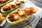 Cooling rack with meat stuffed zucchini boats on table, closeup