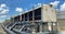 The cooling tower is located in a large data center building installed on the roof on a bright blue sky. And there are white