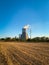 Cooling tower of thermal power plant behind autumn plowed field