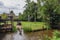 A coop, storks nest, wooden boat and water mill in the yard of a