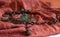 Copper chain with butterflies, beads, decorative leaves on textured terracotta cloth
