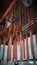 Copper chandelier below rustic wooden ceiling