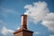 copper chimney with smoke rising against a blue sky
