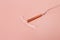 Copper intrauterine contraceptive device on light pink background