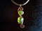 Copper necklace jewel with greenish yellow Agate gemstones on a dark cloth.
