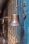 Copper old vintage bell, doorbell, rope on a wooden blue aged wall. Concept decor element in interior of deck, cabin of ship,