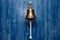 Copper old vintage bell, doorbell, rope on a wooden blue aged wall. Concept decor element in interior of deck, cabin of ship,