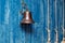 Copper old vintage bell, doorbell, rope on a wooden blue aged wall. Concept decor element in interior of deck, cabin of ship,