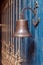 Copper old vintage bell, doorbell, rope on a wooden blue aged wall. Concept decor element in interior of deck, cabin of ship,
