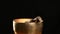 Copper singing bowl rotates around its axis on a black background. Tibetan musical instrument for meditation and alternative medic