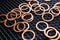 Copper washers on black metal mesh background