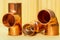 Copper water pipe fittings on wooden board plumbing concept