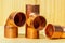 Copper water pipe fittings on wooden board plumbing concept