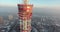 The copter is circling around the TV tower at the background of the city covered with snow. 4k. Panorama view.