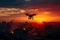 Copter drone over burning city at sunset or sunrise