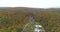 Copter view of landscape. Buildings surrounded by forest and mountains. Nature parks