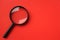 Copy space Black round magnifying glass on red background. used for searching or expanding books.
