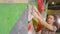 COPY SPACE: Female rock-climber holds on to a hold while training at indoor gym.