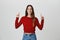 Copy space. Isolated studio portrait of joyful beautiful young girl with dark hair in red sweater and jeans smiling with