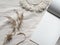 Copy space n block note. Envelope, macrame, pampas grass.. Simple minimal flat lay on ivory textile with dry earth color