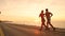 COPY SPACE: Unrecognizable young couple jogs down ocean road at stunning sunset.