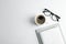 Copybooks, cup of coffee and glasses on white background