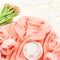 Coral color plush comfy bathrobe with flowers and coffee. Relaxation at home concept, flat lay