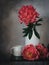 Coral peonies and a cup on a dark background