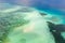 Coral reef with turquoise water and sandy shoals. Large atoll with beautiful lagoons. Tourists relax in the warm sea water