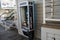 A corded landline phone in a public payphone phone booth on the boardwalk pier.