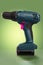 Cordless battery drill on gradient green with pink buttons