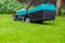 Cordless battery power lawn mower close up on green grass background