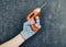 Cordless screwdriver in your hand is used against a gray background