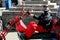 Corfe, England - June 03 2018: Mean looking biker on a chopper trike motorcycle, wearing black and red, with bandanas covering his