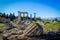 Corinth Greece Temple of Apollo with snow-topped mountains in the distance and chunck of fallen pillars in the foreground