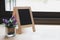 corkboard, artificial flower in small glass pot on a wooden table.