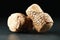 Corks of wine bottles with grape images on black table, closeup