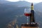 Corkscrew, glass and bottle of red wine on barrel against mountain landscape, space for text