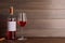 Corkscrew near bottle and glass of delicious rose wine on table against wooden background. Space for text